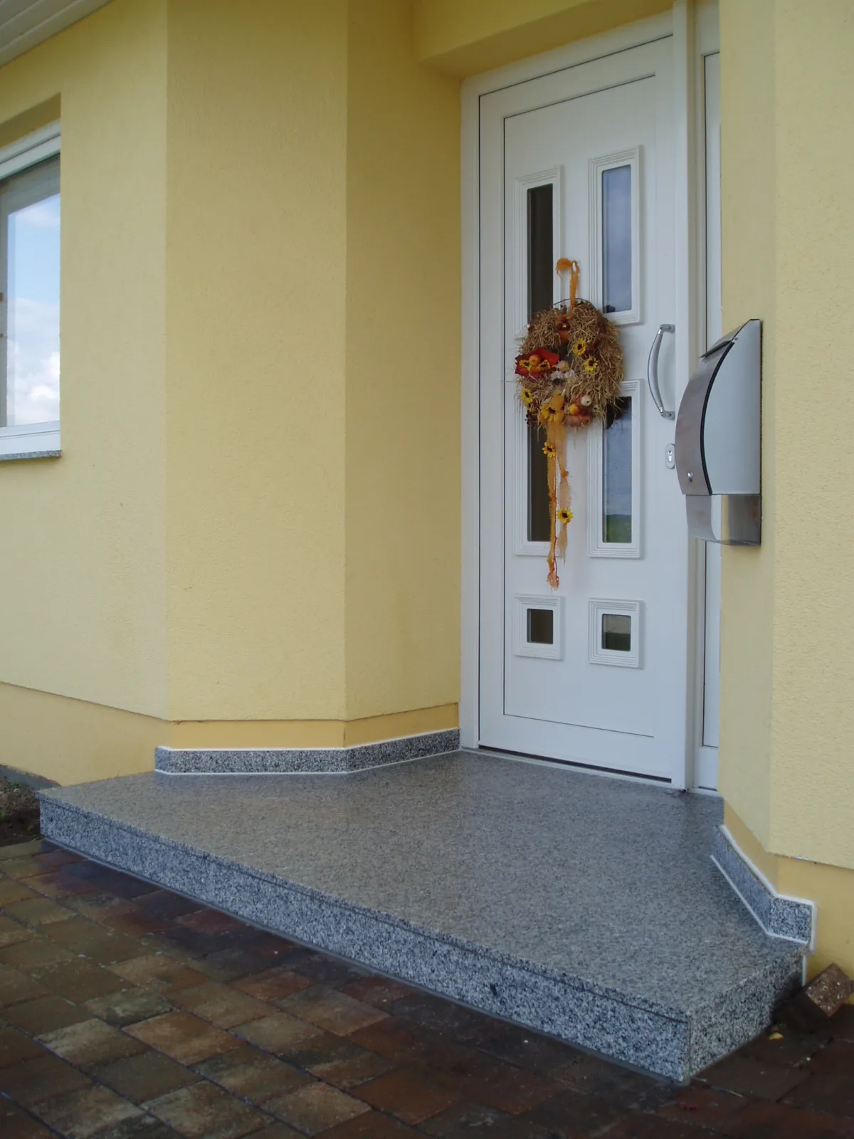 Eingangsbereich mit Granit-Natursteinplatten und Blockstufen
