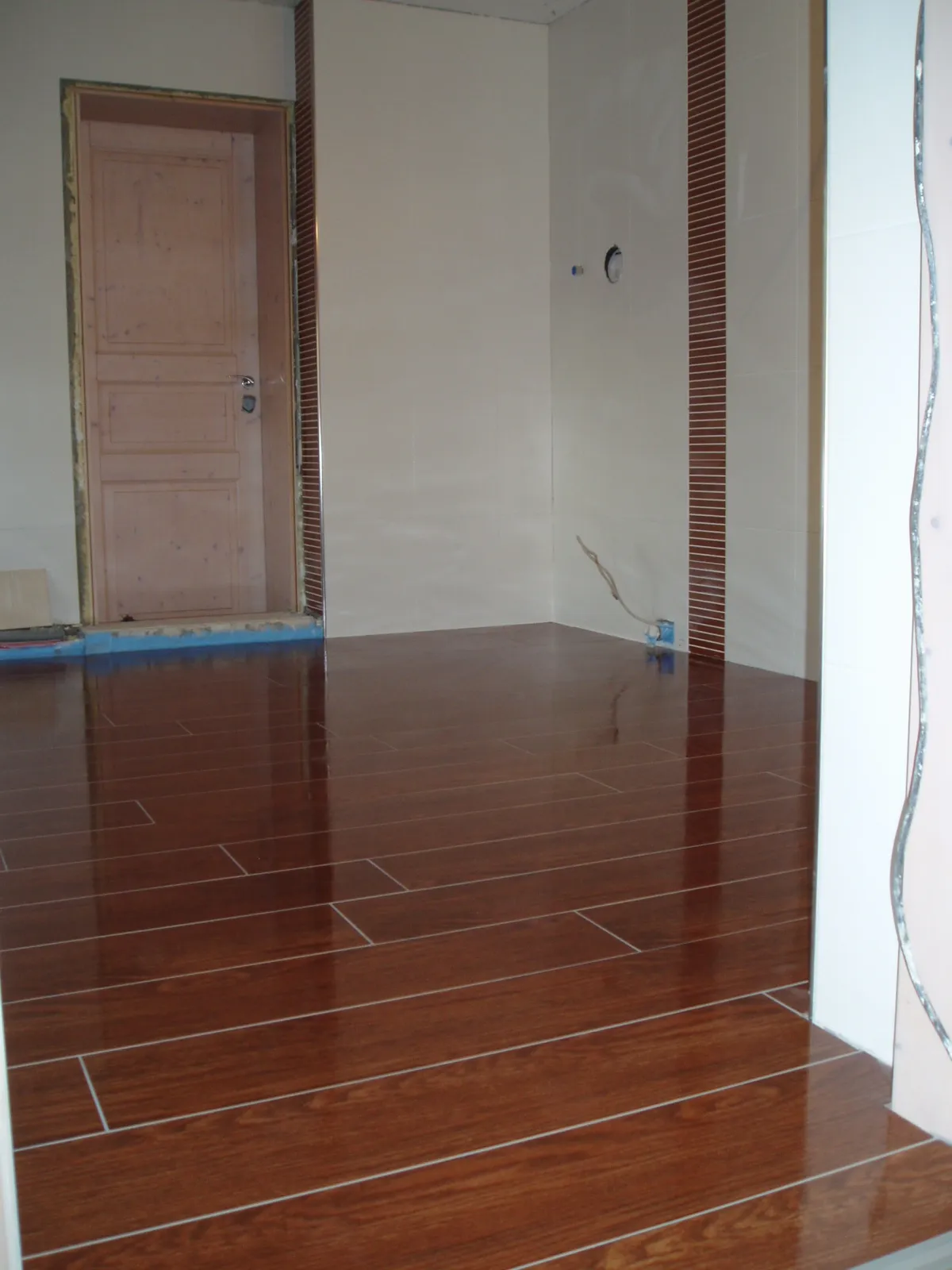 Wohnraum mit Holzoptik-Fliesen und Designboden in Parkettstruktur